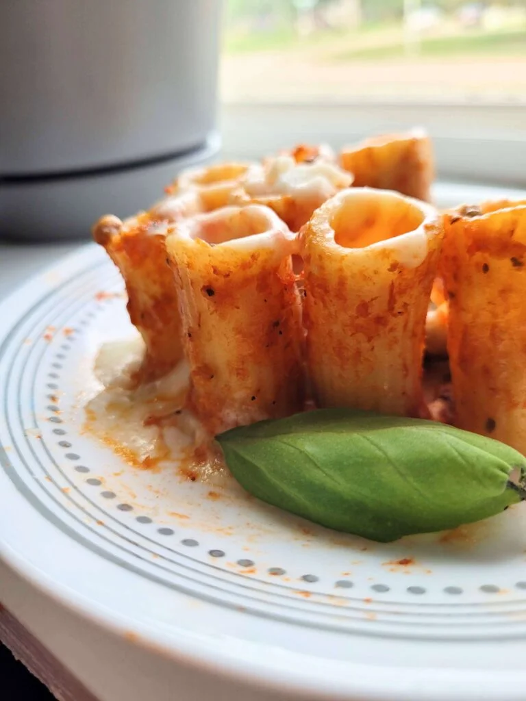 stuffed rigatoni with basil on a plate. 