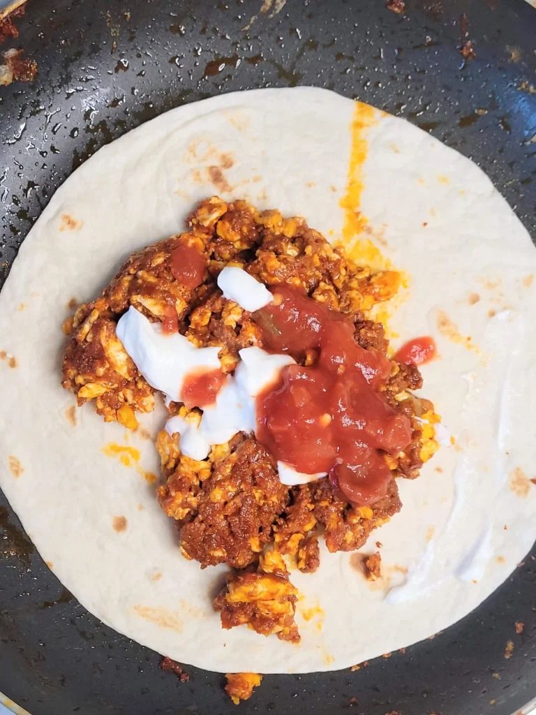 chorizo and egg tacos top view with sour cream and salsa.